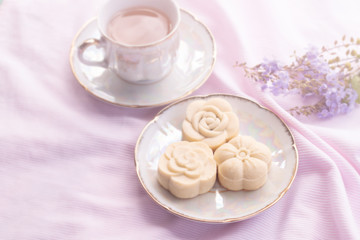 Home-made cheese tart on vintage ceramic plate with hot tea on sweet pink tone