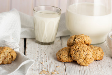 Oatmeal cookies with milk on tray on rustic wooden table