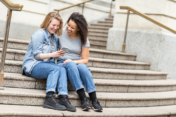 Lesbian couple using their mobile phone