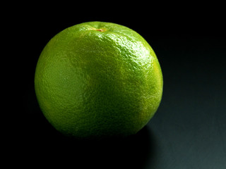 Green grapefruit on a dark background