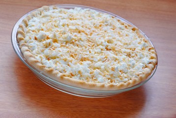 A freshly baked coconut cream pie sitting on a wooden table