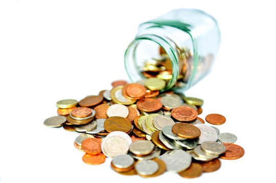 Cut Out Of Glass Jar Full Of Uk British Coins Spilling Out On White Background