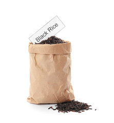 Paper bag with uncooked black rice and card on white background