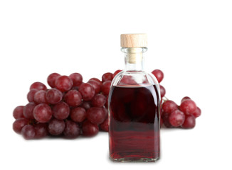 Obraz na płótnie Canvas Glass bottle with wine vinegar and fresh grapes on white background