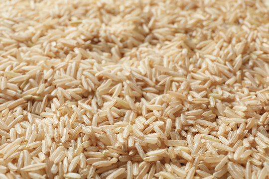 Raw brown rice as background, closeup view