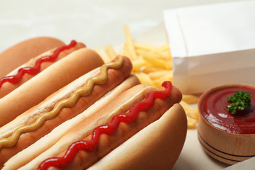 Tasty hot dogs with mustard and ketchup on table, closeup