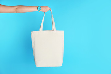 Woman holding eco bag on color background. Mock up for design