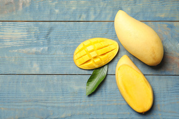 Flat lay composition with mango on wooden background. Space for text