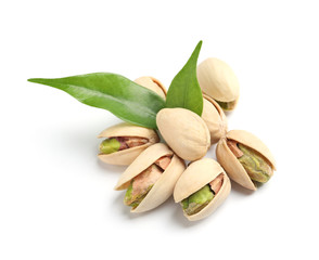 Tasty organic pistachio nuts with leaves on white background