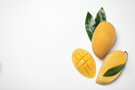Composition with fresh mango fruits on white background, top view. Space for text