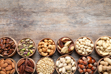 Flat lay composition with organic nuts and space for text on wooden background, top view. Snack mix