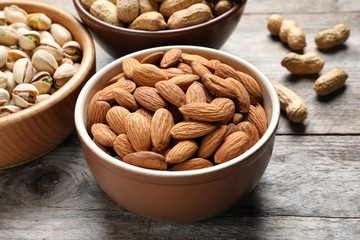 Bowls with organic nuts on wooden table. Snack mix