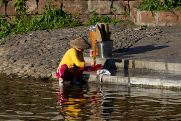Pani piorąca ręcznie ubrania w rzecze © Miroslaw