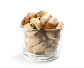 Glass with Brazil nuts on white background