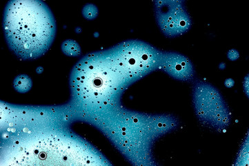 Abstract pattern of bubbles or drops on dark background, various hues of blue