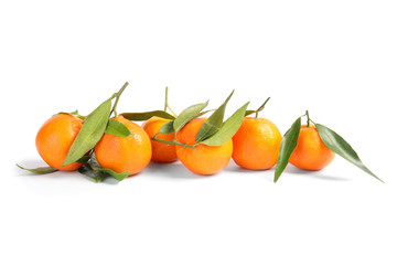 Tasty ripe tangerines with leaves on white background
