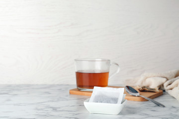 Bowl with tea bags on table. Space for text