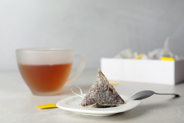 Saucer with used tea bag on table