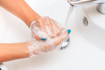 Soaped woman hands in the sink