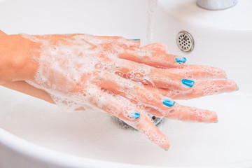 Soaped woman hands in the sink