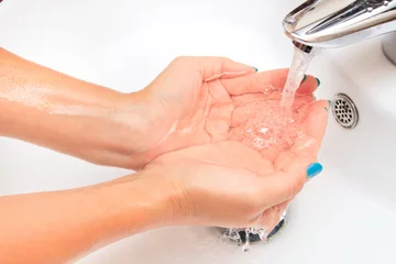 Female hands under running water in the sink © nakedking