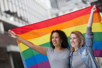 Lesbian couple celebrating pride with an LGBT flag
