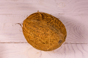One whole coconut on a wooden table. Top view