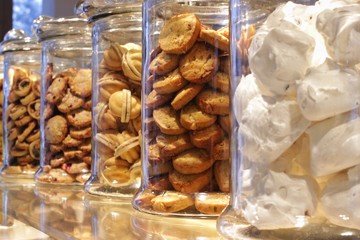 cookies, marshmallows, sweets in glass jars on a shop window