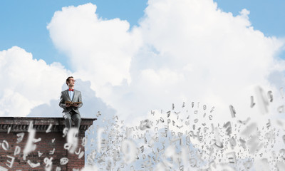 Young businessman or student studying the science and symbols fly around