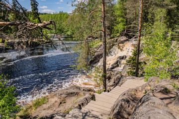 Naklejka na ściany i meble Foamy streams of water Tahmayoki River on the waterfall Ahinkoski