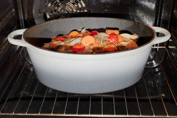 Duck topped with vegetables roasting in an oven