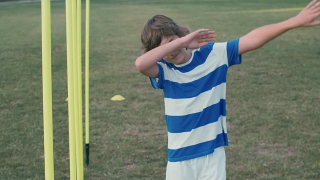 Kid boy soccer player doing celebration gesture on a field, 4k slow motion