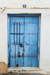 Wooden blue Door with stella grate on a white wall in Estepona Spain