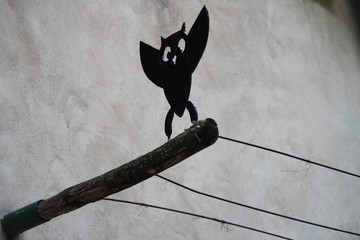 wrought iron owl leaning on a wood