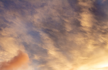 Clouds during sunset. The sky is dyed golden colors.