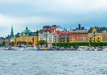 View on the pier with boats and the beautiful buildings of Stromkayen in the center of Stockholm Sweden