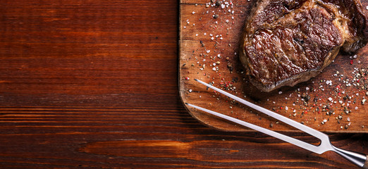 tasty and fresh, very juicy ribbey steak of marbled beef, on a wooden table.