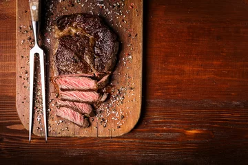 Tuinposter tasty and fresh, very juicy ribbey steak of marbled beef, on a wooden table. © Mikhaylovskiy 