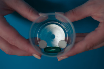 girl holding a transparent container with pills