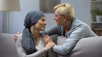 Mother hugging and kissing her hopeless daughter with cancer, family support