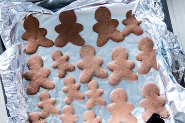 Chocolate gingerbread mans on foil and baking sheet
