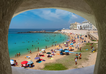 Wide view of the coastline of Ionian sea and people on the beach in summertime in Gallipoli, Lecce region of Italy