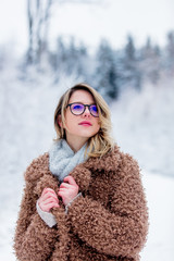 Beautiful girl in coat in a snow forest. Christmas of Valentine Day season time