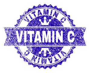 VITAMIN C rosette stamp overlay with grunge style. Designed with round rosette, ribbon and small crowns. Blue vector rubber print of VITAMIN C title with unclean style.