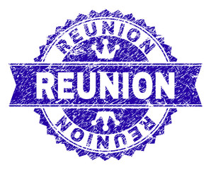 REUNION rosette stamp seal watermark with grunge effect. Designed with round rosette, ribbon and small crowns. Blue vector rubber watermark of REUNION label with grunge texture.