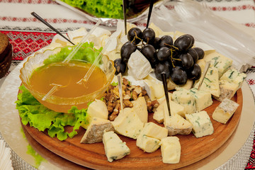 Cheese plate with variety of appetizers on table