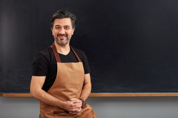 Adult cafe owner posing on blackboard.