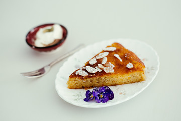 piece of orange and almond cake with cream on the table