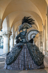 Fototapeta na wymiar Venice Carnival masks and costumes under the arcade of the Doges Palace Piazza san Marco