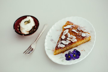 piece of orange and almond cake with cream on the table